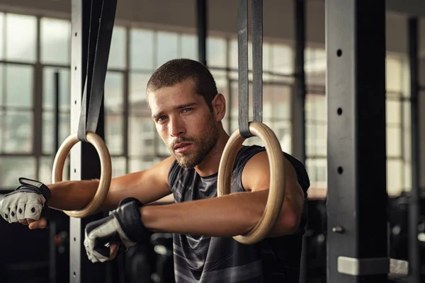 Homem de fitness descansando em anéis de mergulho — Fotografia de Stock