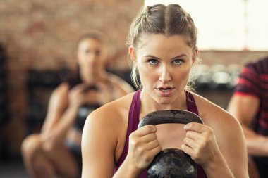 Kettle bell ile çömelme yapıyor Kararlı fitness kadın