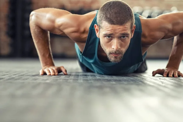 Zdecydowany człowiek robi push up na siłowni — Zdjęcie stockowe