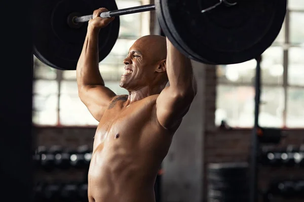 Güçlü siyah adam ağırlık kaldırma yapıyor — Stok fotoğraf
