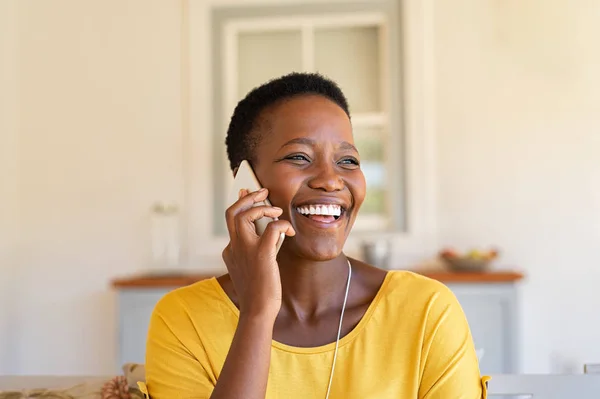 Woman laughing while talking on phone — ストック写真