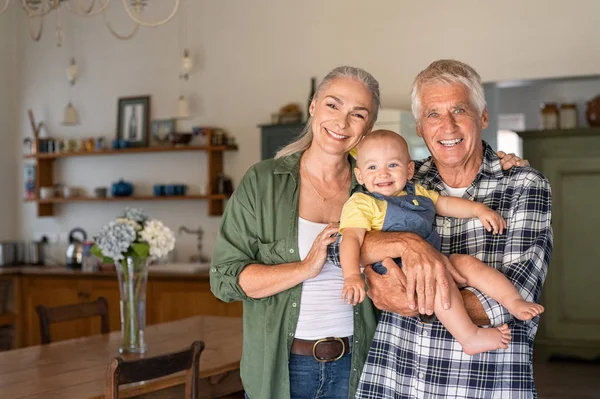 Feliz abuelos sosteniendo nieto sonriente —  Fotos de Stock