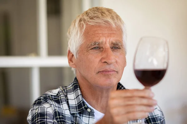 Старик пробует красное вино — стоковое фото