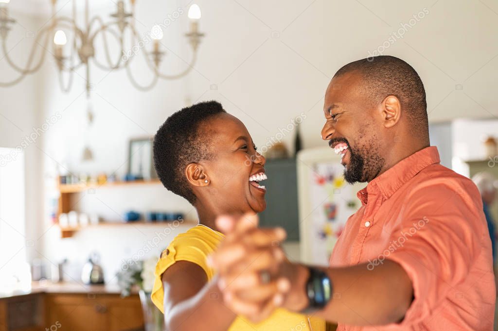 Mature happy couple dancing at home