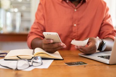Akıllı telefon kullanan ve makbuz tutan adam elleri