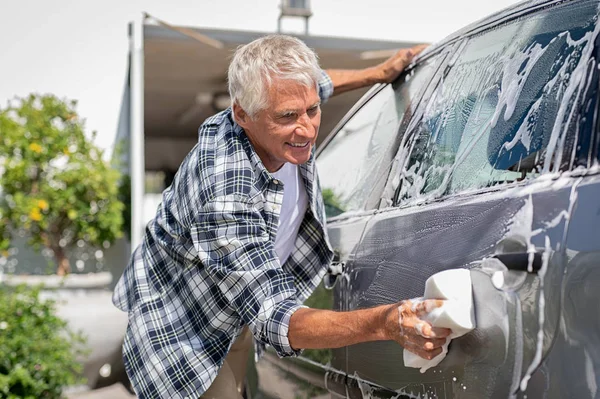 Χαμογελαστός άνθρωπος που πλένει το αυτοκίνητό του — Φωτογραφία Αρχείου