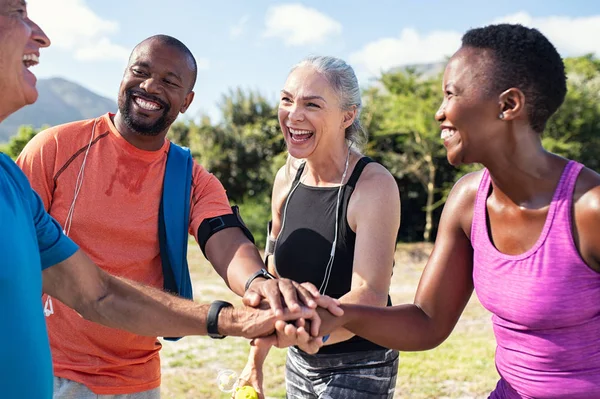 Mature people stacking hands after workout — Stock Photo, Image