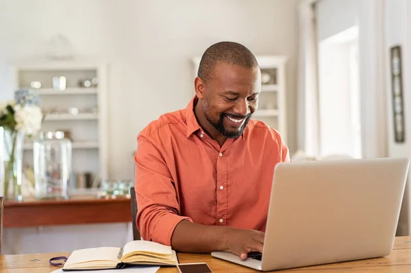 Boldog érett fekete ember használ laptop — Stock Fotó