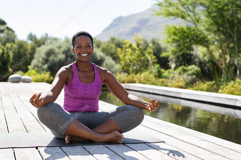 Mature african woman in yoga lotus position