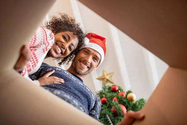 Multi-etnische paar uitpakken kerstcadeau — Stockfoto