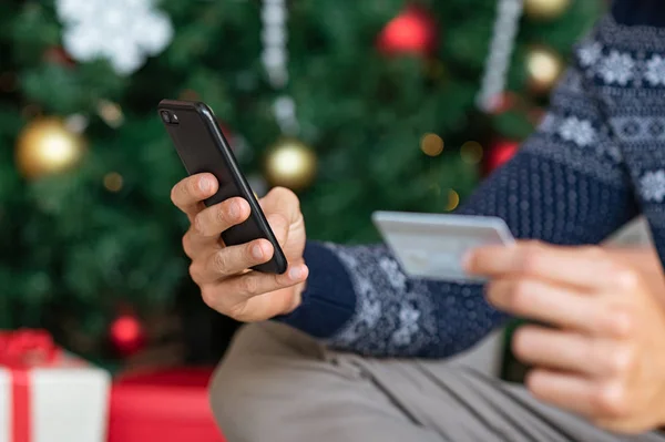 Homem mão segurando telefone e cartão no Natal — Fotografia de Stock