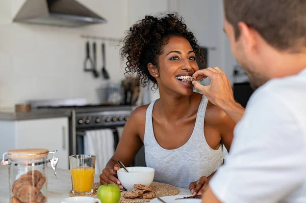Man voeden cookie aan vrouw voor ontbijt thuis — Stockfoto