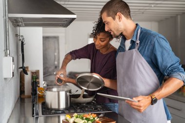 Yemek yaparken tencereye tuz ekleyen kadın