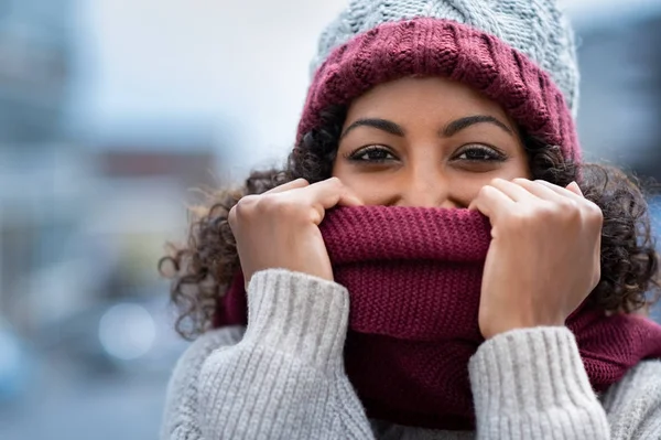 Hermosa mujer escondiendo la cara en una bufanda de lana —  Fotos de Stock