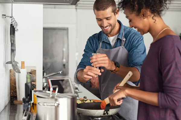 Mann fügt Pfeffer in Tomatensauce hinzu — Stockfoto