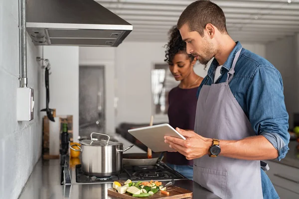 Coppia cucina insieme con tablet digitale — Foto Stock