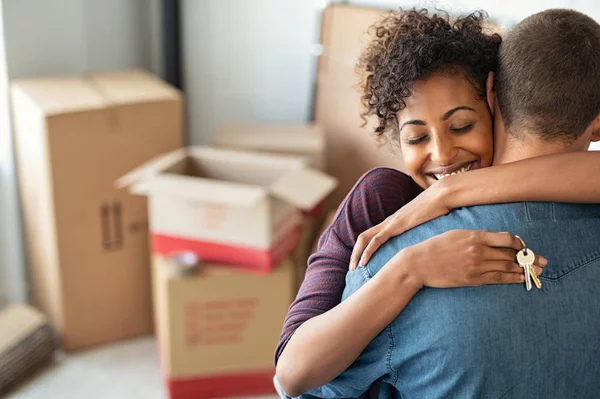 Woman hugging man and holding home keys — Stock Photo, Image