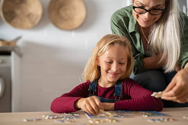 Großmutter und Enkel lösen Puzzle — Stockfoto