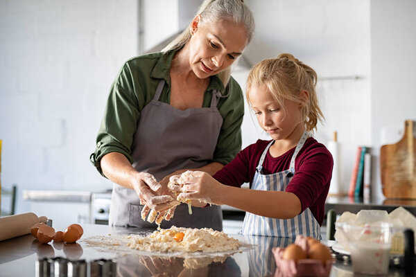 Grandmother and granddaughter preparing dough