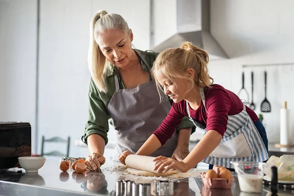 Liten flicka rullande deg med mormor — Stockfoto