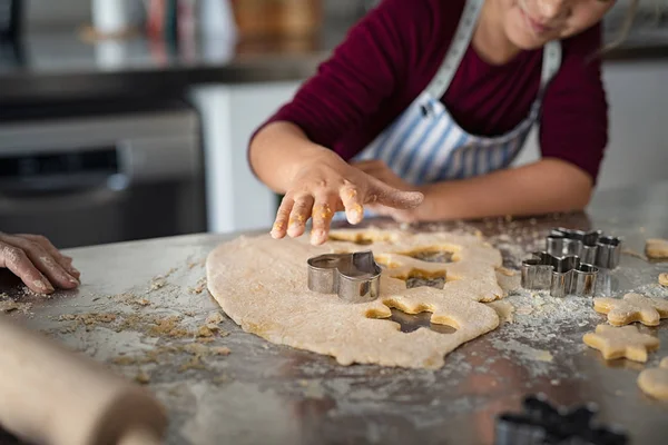 Kind snijden deeg voor kerstkoekjes — Stockfoto