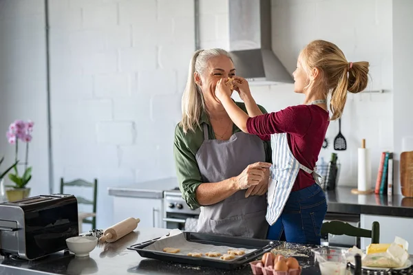 Abuela y nieta jugando mientras hacen galletas —  Fotos de Stock