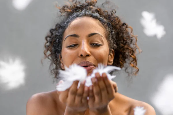 Africano mulher soprando penas — Fotografia de Stock