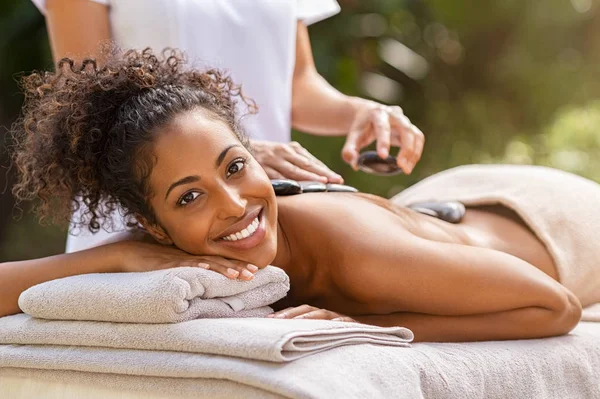 Mulher fazendo massagem com pedras quentes no spa — Fotografia de Stock