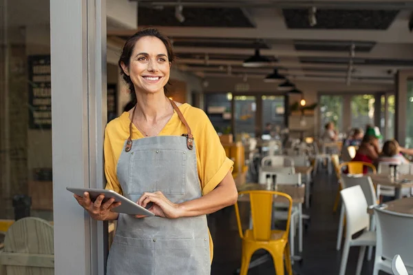 Framgångsrik ägare står vid caféentrén — Stockfoto