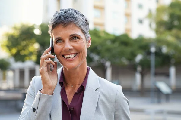 Зрелая деловая женщина разговаривает по телефону на открытом воздухе — стоковое фото