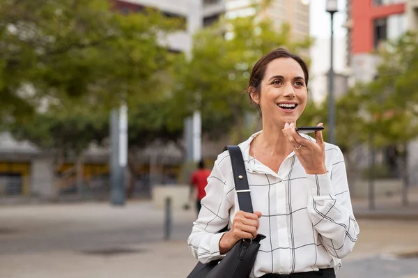 Ділова жінка використовує динамік телефону на відкритому повітрі — стокове фото
