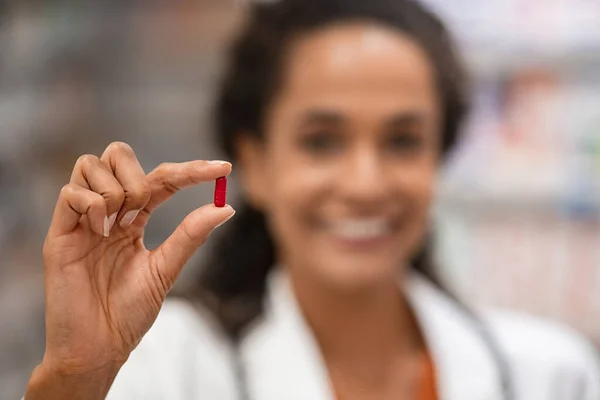 Close Red Analgesic Pill Held Hand Mixed Race Pharmacist Smiling — Stock Photo, Image