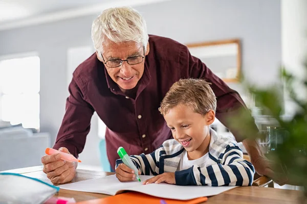 Senior Man Bär Glasögon Hjälpa Smart Pojke Slutföra Sina Läxor — Stockfoto