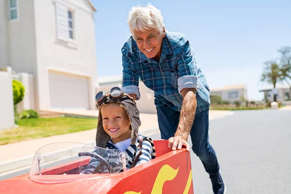 Großvater Hilft Enkel Auf Spielzeugauto Freien Fahren Älterer Mann Schiebt — Stockfoto