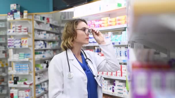 Ώριμη Γυναίκα Φαρμακοποιός Στο Φαρμακείο Φορώντας Παλτό Στηθοσκόπιο Επαγγελματίας Γιατρός — Αρχείο Βίντεο