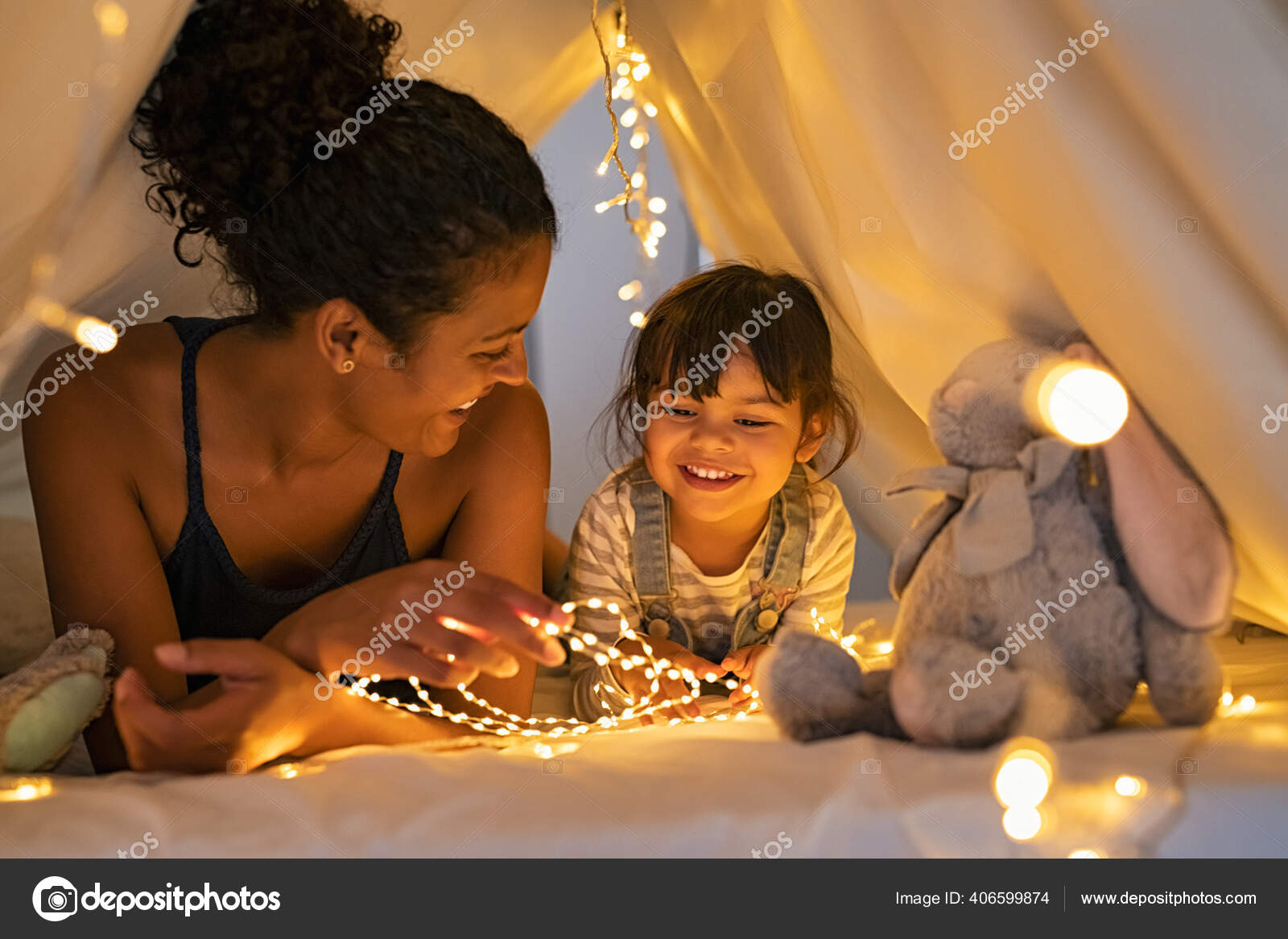 Sorridente menina deitada no sofá confortável, gostando de jogar