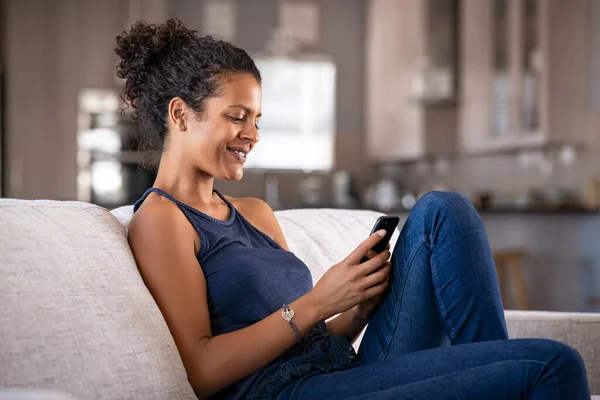 Jovem Mulher Africana Alegre Usando Smartphone Enquanto Senta Sofá Mulher — Fotografia de Stock