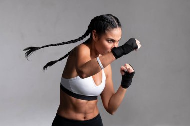 Kararlı orta yaşlı kadın boksör boks maçına hazırlanıyor. Spor salonunda boks antrenmanına hazırlanan orta yaşlı bir kadın. Boks eldivenli güzel güçlü sporcu kadın sağ yumruğu hazırladı..