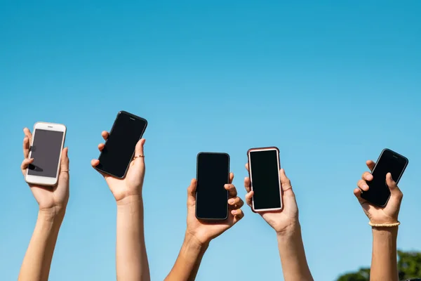 Adolescentes Mãos Segurando Telefones Celulares Levantando Contra Céu Azul Grupo — Fotografia de Stock