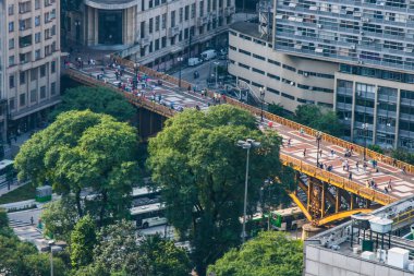 Şehir merkezinde ışık güneş tarafından aydınlatılmış altın metalik köprü