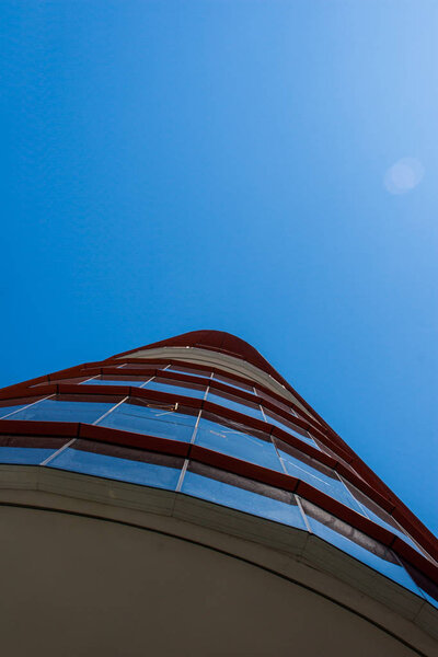 A blue and red office building detail with beautiful blue sky on the background
