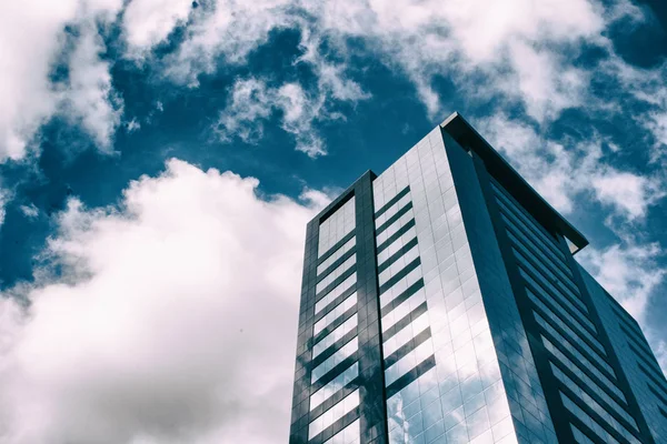 Hermoso reflejo de las nubes en las ventanas de cristal de un edificio de oficinas — Foto de Stock