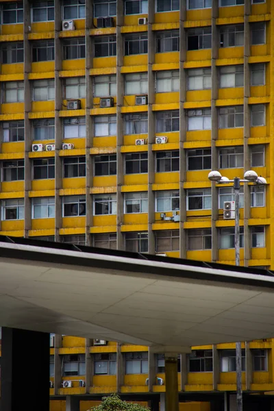 Edificio antiguo de oficinas amarillo con estructura metálica moderna en frente — Foto de Stock