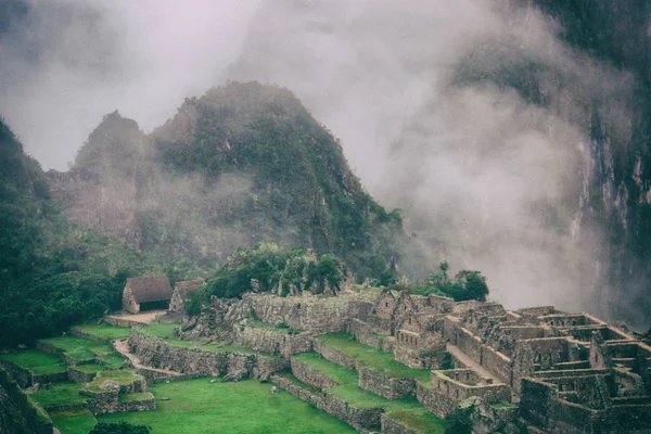 雾覆盖了马丘比丘古老废墟后面的山脉。秘鲁。没有人. — 图库照片