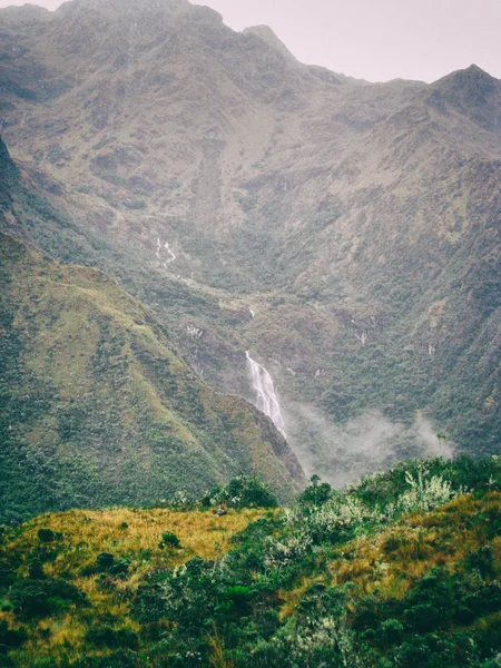 Cascada en las montañas verdes en la niebla . — Foto de Stock