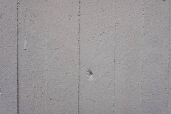 Witte verticale balken muur met krassen en een gat. — Stockfoto