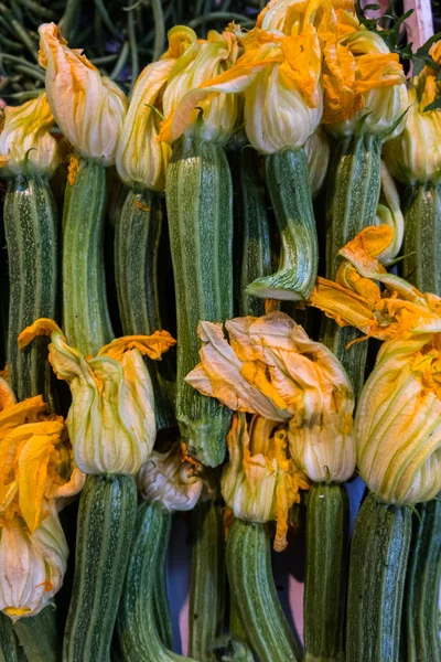 City market stall with fresh courgette flowers.