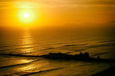 Güneş, dalgalar ve kıyı.