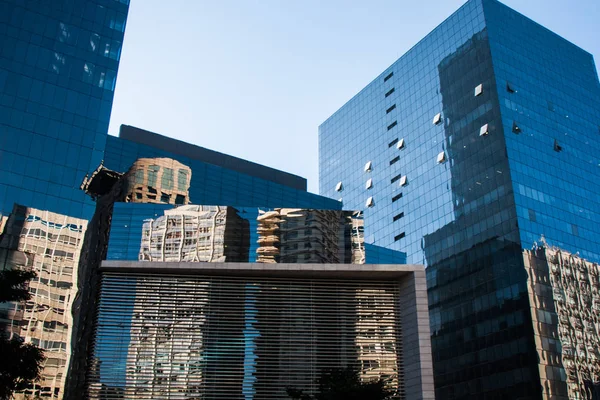 Reflejo de edificios blancos en ventanas de edificios corporativos de vidrio azul — Foto de Stock