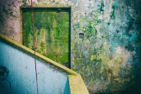 Abgenutzte gelbe Tür und blaue Wände in einem verdammten Gebäude. Kein Volk. — Stockfoto